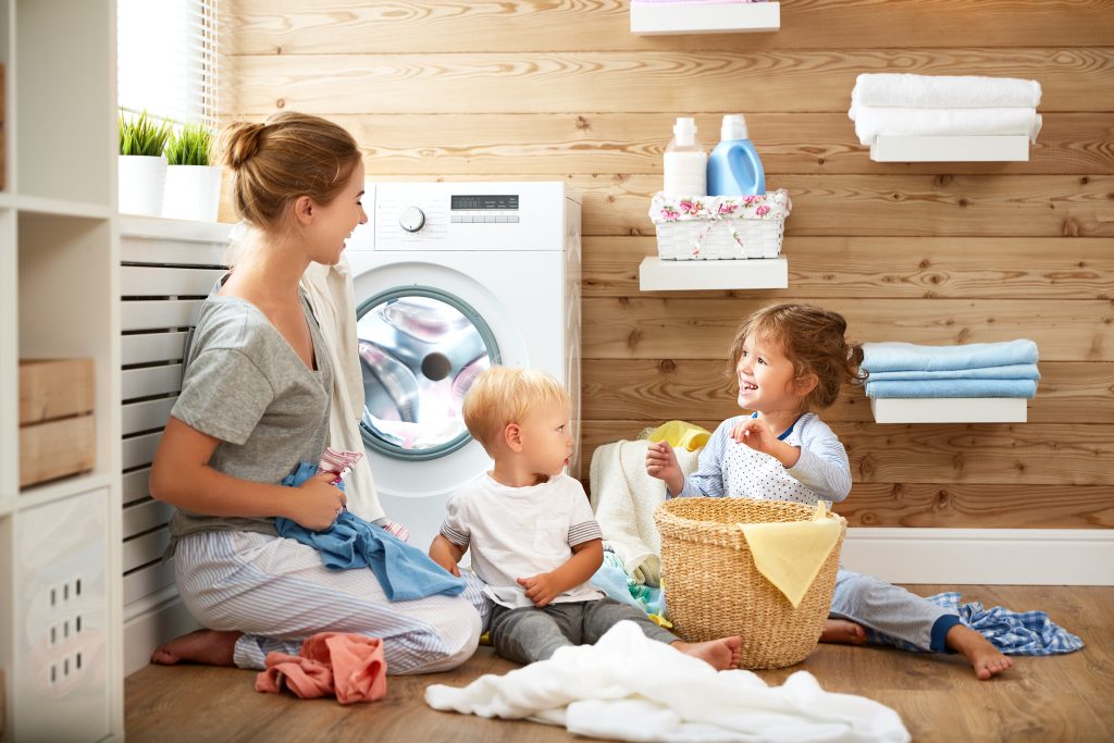 Happy family mother and children in laundry load washing machine powered by Pentair - Kolam, Water Treatment, and Flow Technologies