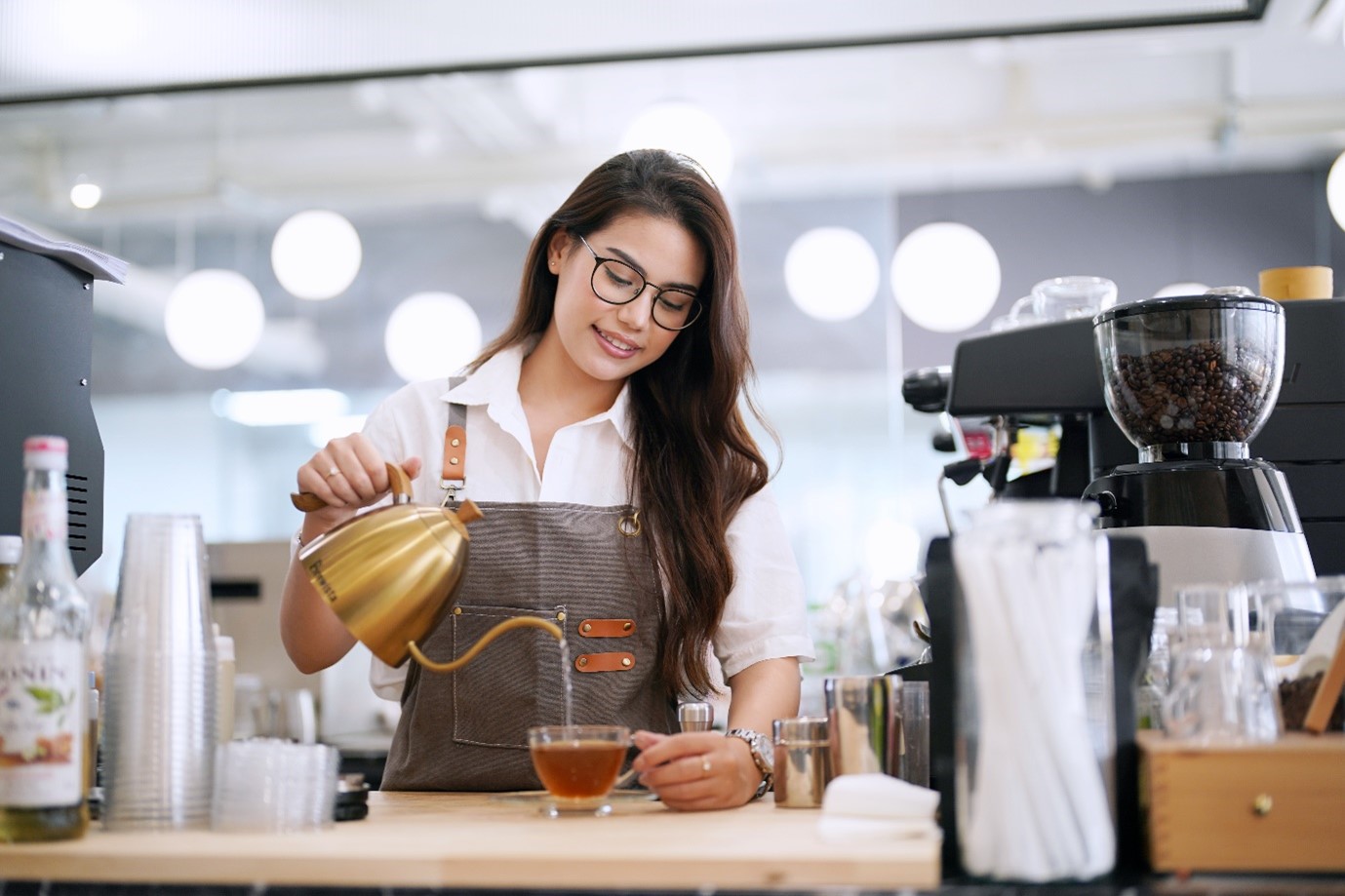 Woman pouring tea into tea cup powered by Pentair Water Filtration Solutions