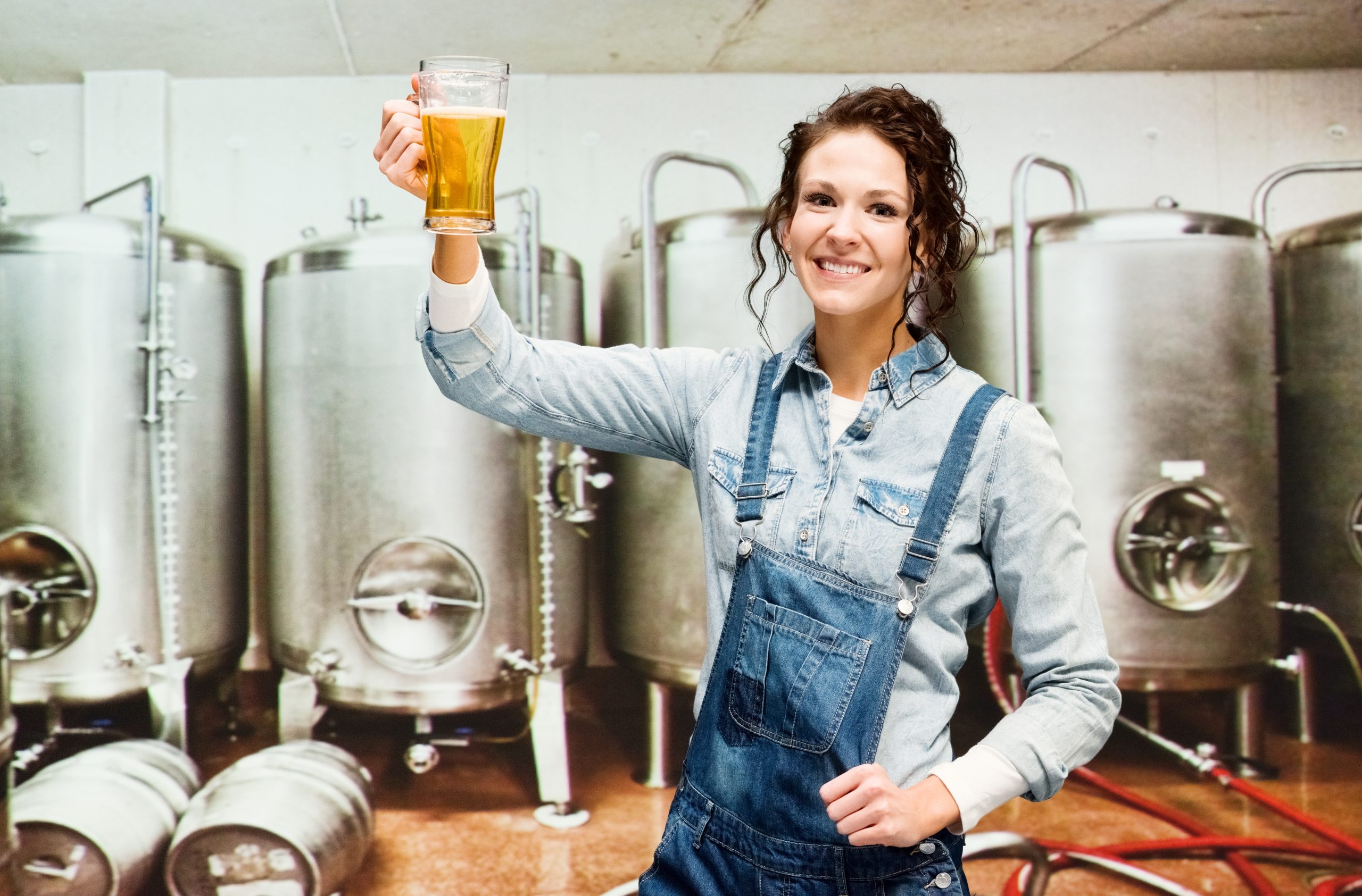 Smiling brewmaster holding beer glass in brewery by Pentair Sản Xuất Bia powered by Pentair GIẢI PHÁP CÔNG NGHIỆP